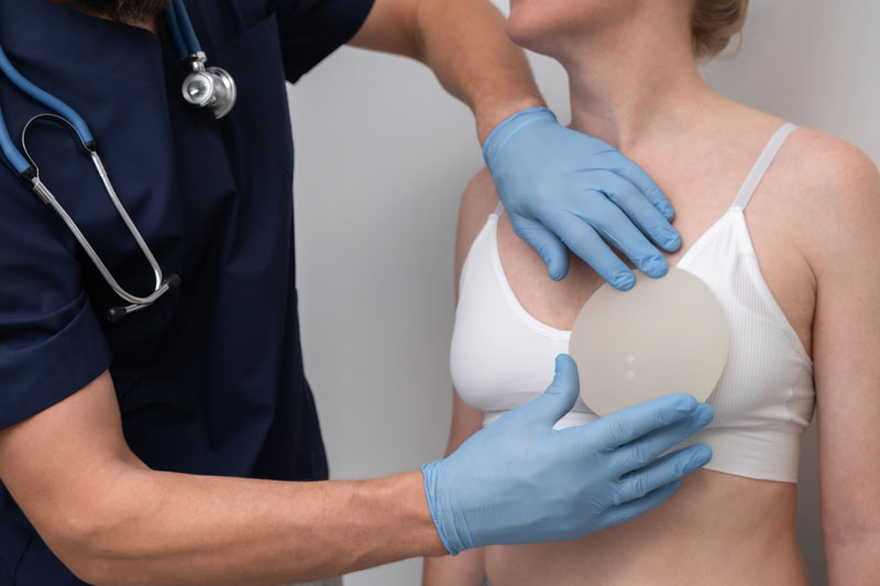 A plastic surgeon taking measurements before a breast enlargement procedure