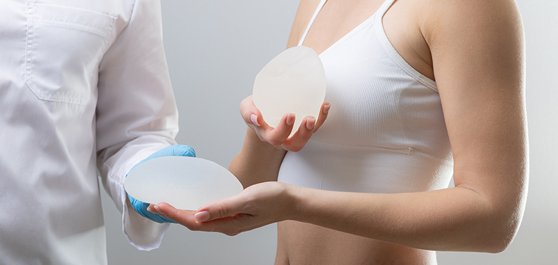 A doctor and patient discussing a breast implant during a clinic consultation.