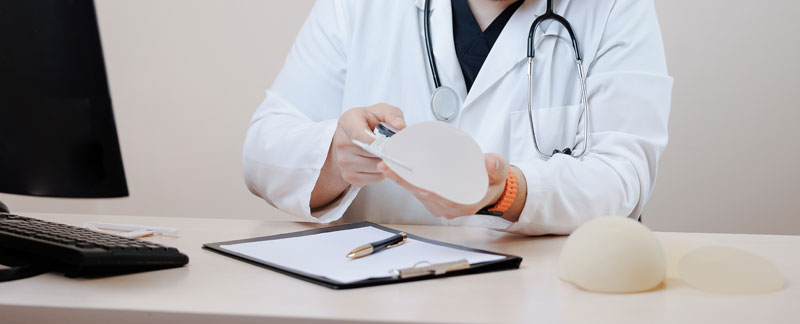 A plastic surgeon examining different breast implants