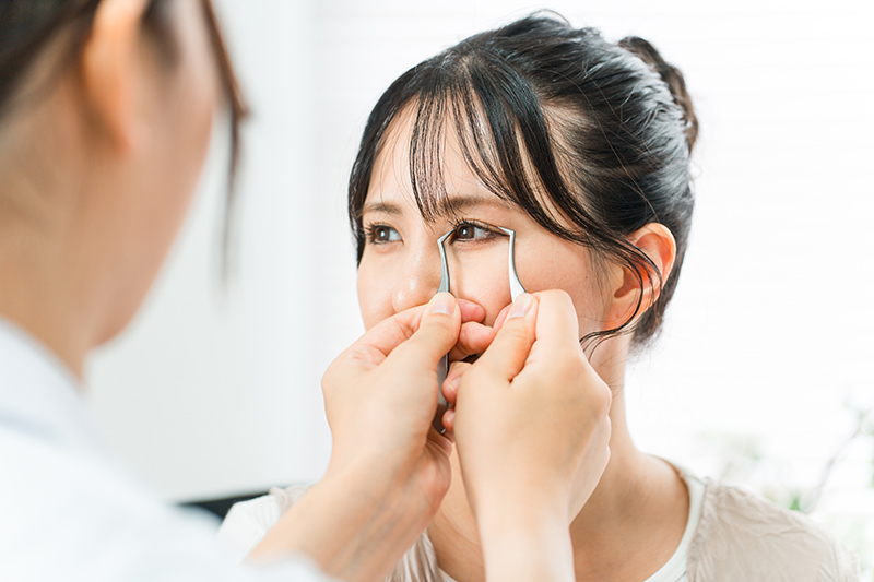 A plastic surgeon measuring the dimensions of a patient's eye