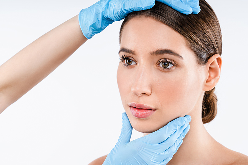 Double eyelid surgeon assessing patient